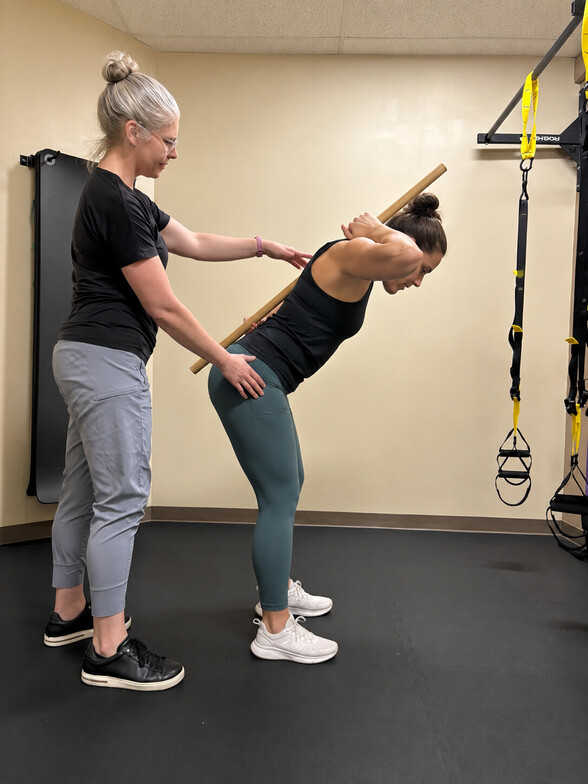 Dr. Erin Strauch-Ducat demonstrating a proper hip hinge to reduce low back strain in Bloomingdale, IL.
